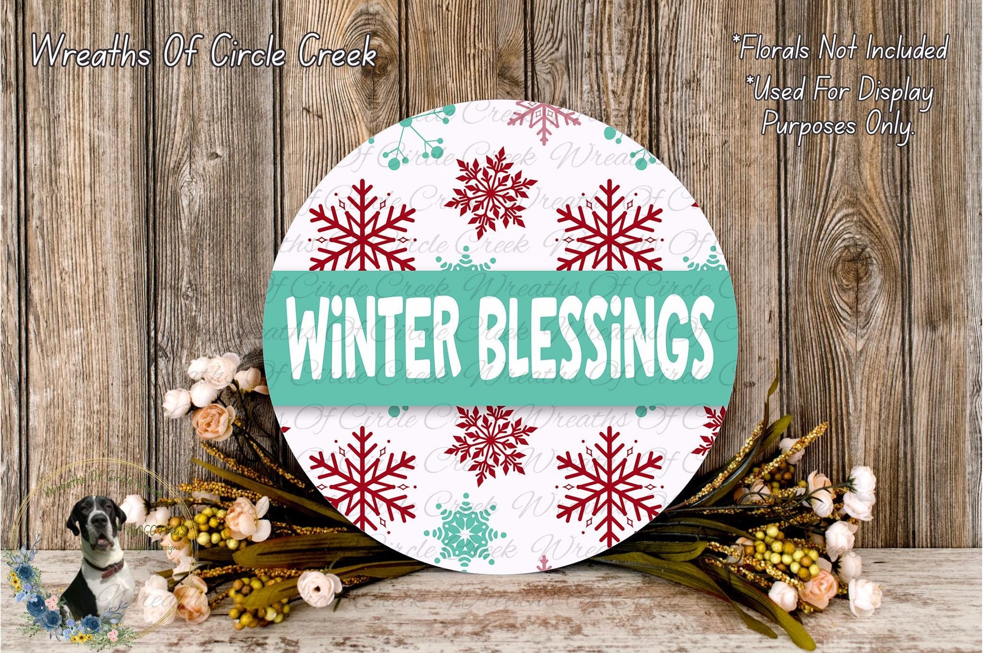 A round sign with the text "Winter Blessings" displayed on it, surrounded by a wreath of flowers and greenery.