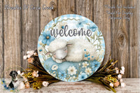 A decorative welcome sign with a sleeping lamb and flowers, placed on a wooden surface.