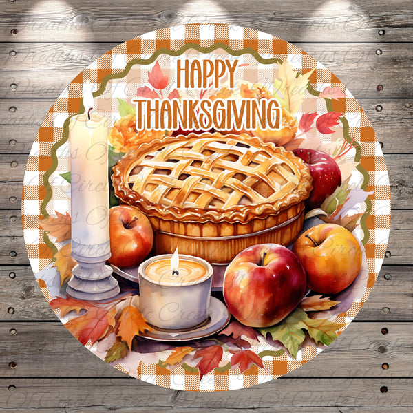 A round Thanksgiving-themed decoration with a pie, apples, a candle, and autumn leaves.