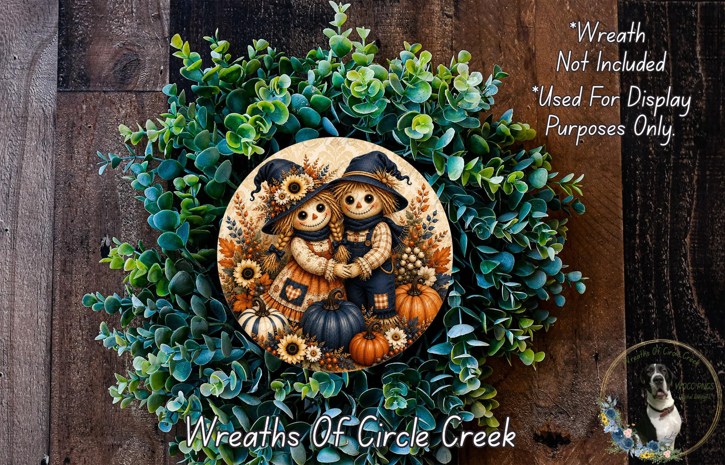 a wreath with a decorative design of two scarecrow figures, surrounded by various fall-themed elements such as pumpkins, leaves, and sunflowers. The wreath is set against a backdrop of a wooden wall, creating a rustic and seasonal atmosphere.