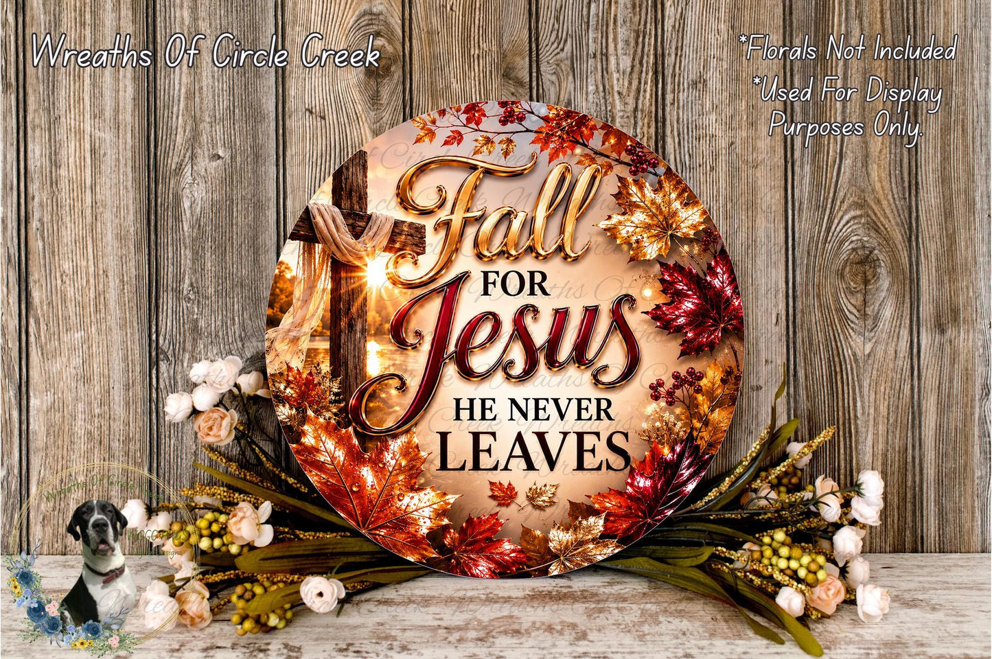 a circular sign with the text "Fall for Jesus he never leaves" surrounded by autumn leaves and flowers. The sign is placed on a wooden surface, and there are additional floral arrangements in the background.