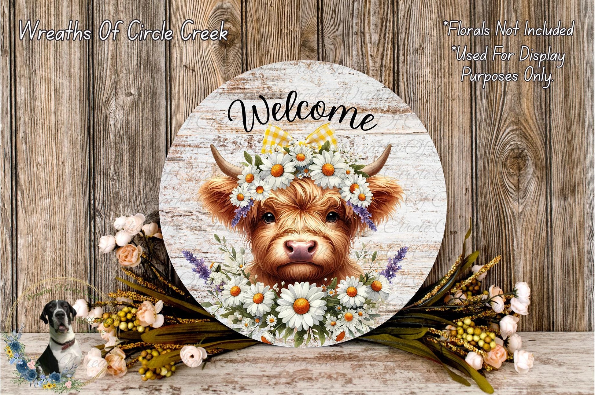 a wooden sign with a cow's head and a floral wreath, surrounded by flowers and greenery. The sign has the word "Welcome" written on it.