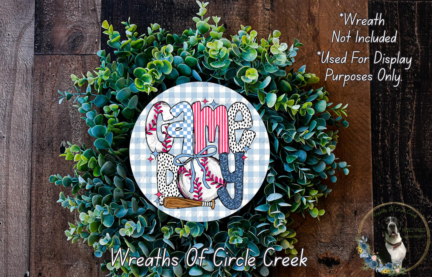 a wreath made of green leaves and a circular sign with the word "GAMES" written on it, placed on a wooden surface.