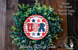 A wreath made of green leaves and featuring a red and white circular sign with the text "USA" in the center.