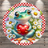 A whimsical illustration of a frog holding a heart, surrounded by flowers and a checkered border.