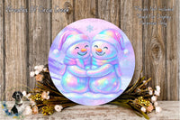 A round, colorful wreath with two smiling snowmen on it, surrounded by flowers and placed on a wooden surface.