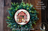A wreath made of green foliage and featuring a red barn, boots, and a poinsettia plant, with the text "Merry Christmas" and "Wreaths of Circle Creek" displayed.