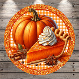 A large orange pumpkin with a whipped cream pie on top, surrounded by cinnamon sticks, anise seeds, and autumn leaves, all set against a wooden background with a glittery border.