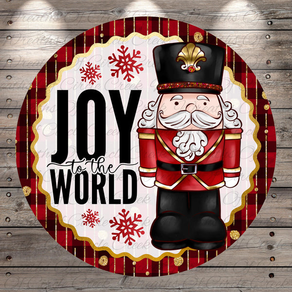 A cheerful illustration of a nutcracker soldier with a hat and a message that says "Joy to the World" against a red and gold background with snowflakes.