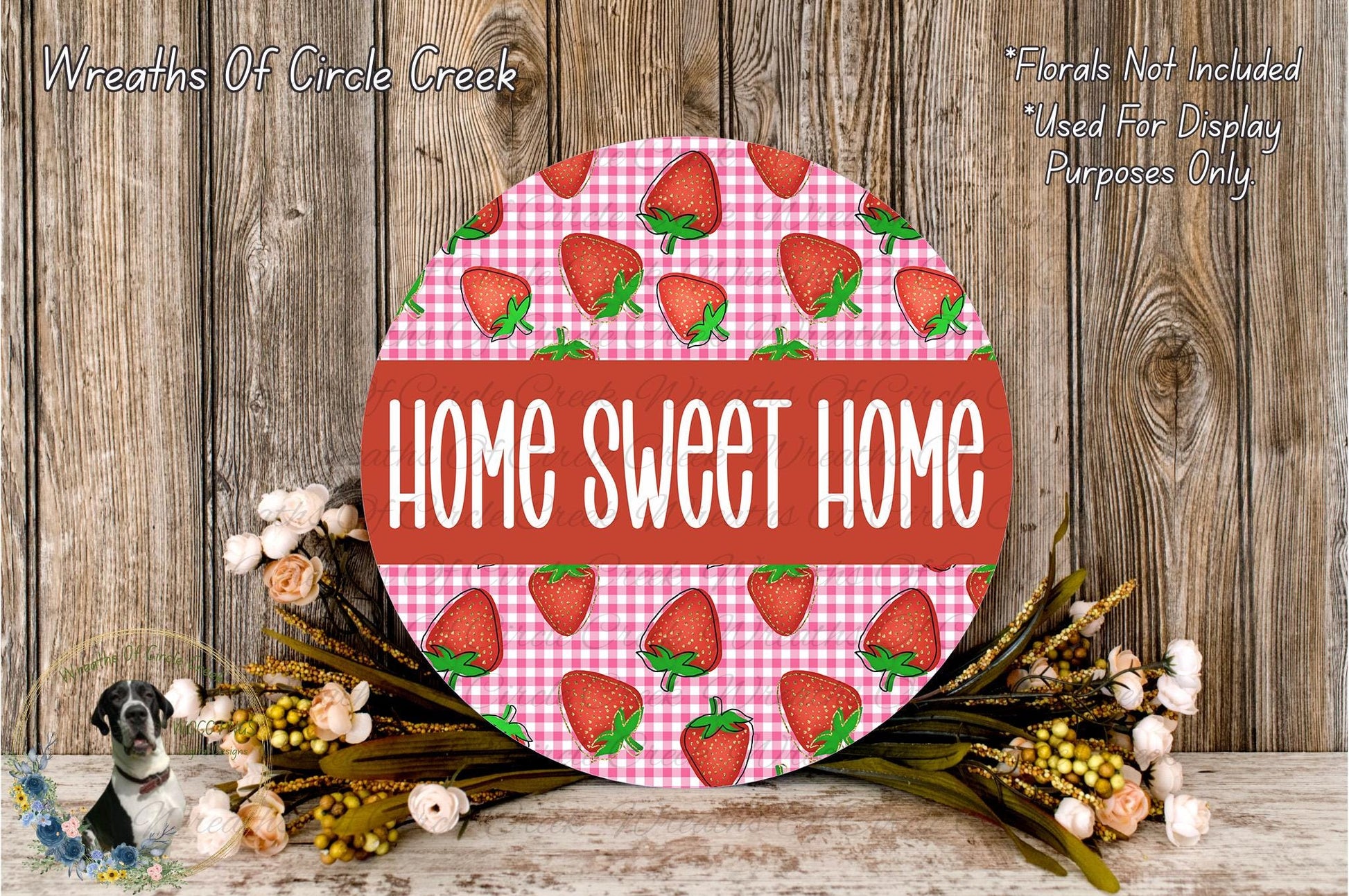 a round sign with the text "HOME SWEET HOME" in bold letters, surrounded by a floral arrangement of flowers and greenery.