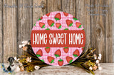 a round sign with the text "HOME SWEET HOME" in bold letters, surrounded by a floral arrangement of flowers and greenery.
