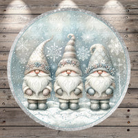 A circular illustration featuring three gnomes wearing winter clothing and hats, set against a snowy background with snowflakes.