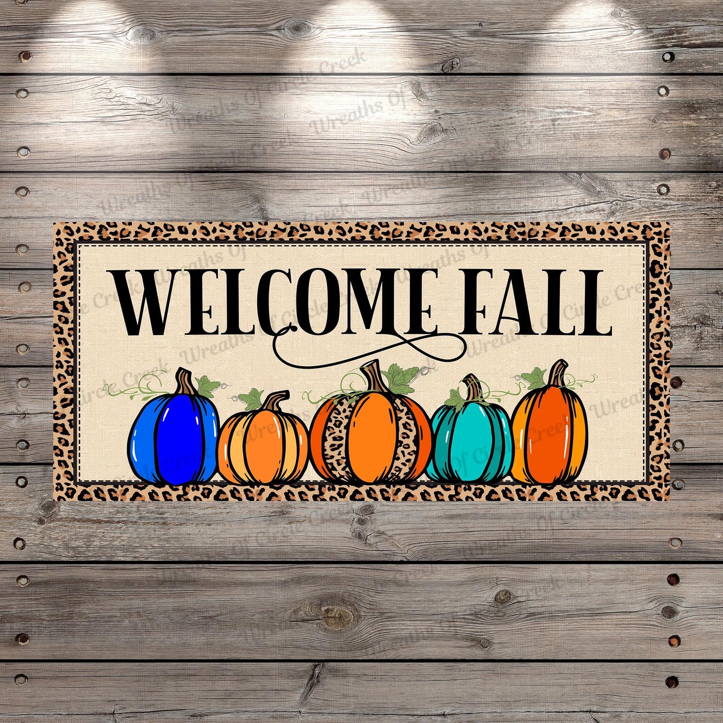 a welcome sign with pumpkins and leopard print