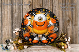 A whimsical, cartoonish monster with a large, round head and a big smile, surrounded by a variety of Halloween-themed elements such as stars, bats, and candy canes. The monster is set against a backdrop of a wooden wall, with a floral arrangement of flowers and greenery placed in front of it.