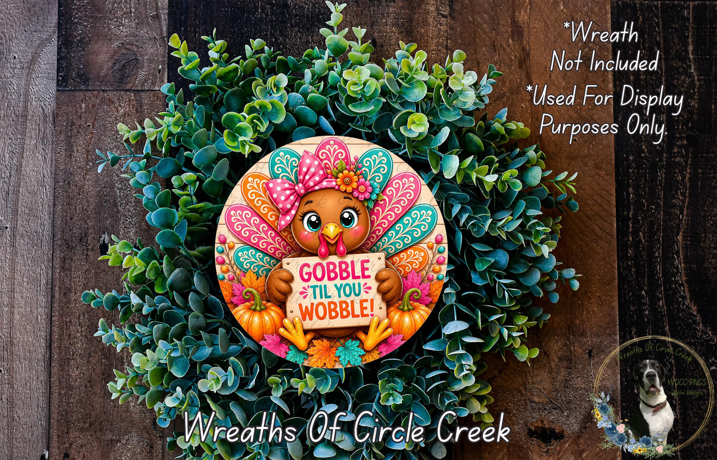 A wreath made of green leaves and a turkey holding a sign that says "GOBBLE TIL YOU WOBBLE!"