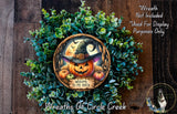 a Halloween-themed wreath with a pumpkin and a witch's hat, surrounded by greenery. The wreath is displayed on a wooden surface, and there is a text overlay that reads "Welcome to my Patch" and "Wreaths of Circle Creek".