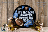 A black circular sign with a football, cheerleader, and flowers, along with the text "It's the most wonderful time of the year" and "GO TEAM!"