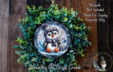A wreath featuring a cute penguin wearing a hat and scarf, surrounded by a lush green plant.