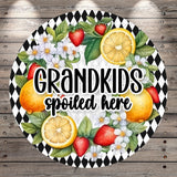 A decorative sign with a black and white checkered pattern, surrounded by various fruits such as strawberries, oranges, and lemons. The sign also features the text "GRANDKIDS spoiled here".