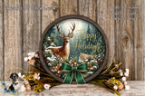 A round wooden frame with a deer and snow-covered forest scene, surrounded by a green bow and flowers, against a wooden background.