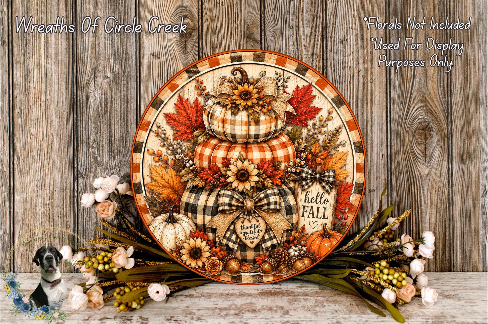 A decorative wreath with autumn-themed elements, including pumpkins, sunflowers, and leaves, displayed on a wooden surface.
