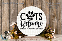 a circular sign with the text "CATS WELCOME (HUMANS BY APPOINTMENT ONLY)" surrounded by a floral arrangement and a wooden background.