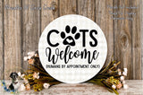 a circular sign with the text "CATS WELCOME (HUMANS BY APPOINTMENT ONLY)" surrounded by a floral arrangement and a wooden background.