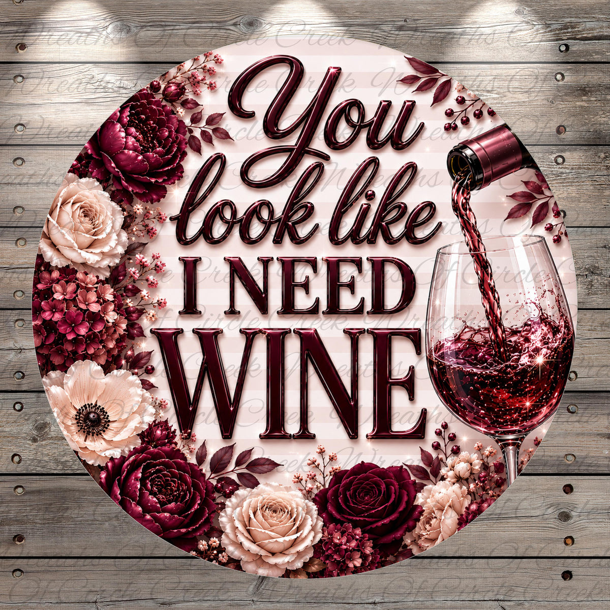 a decorative round sign with a floral border and a wine glass pouring red wine. The sign has the text "You look like I need wine" written on it.
