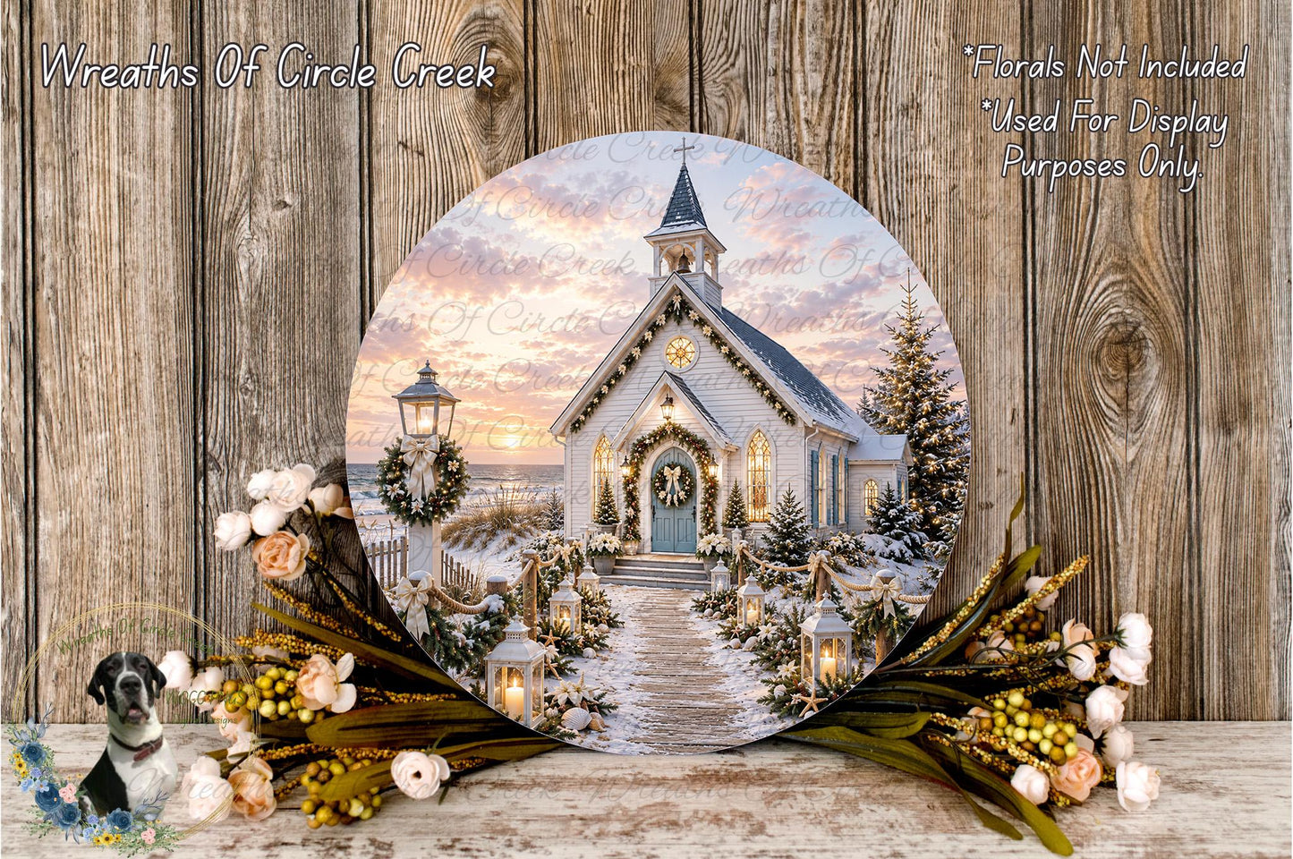 A round wooden plaque displaying a winter scene of a church with a wreath and flowers, set against a wooden background.