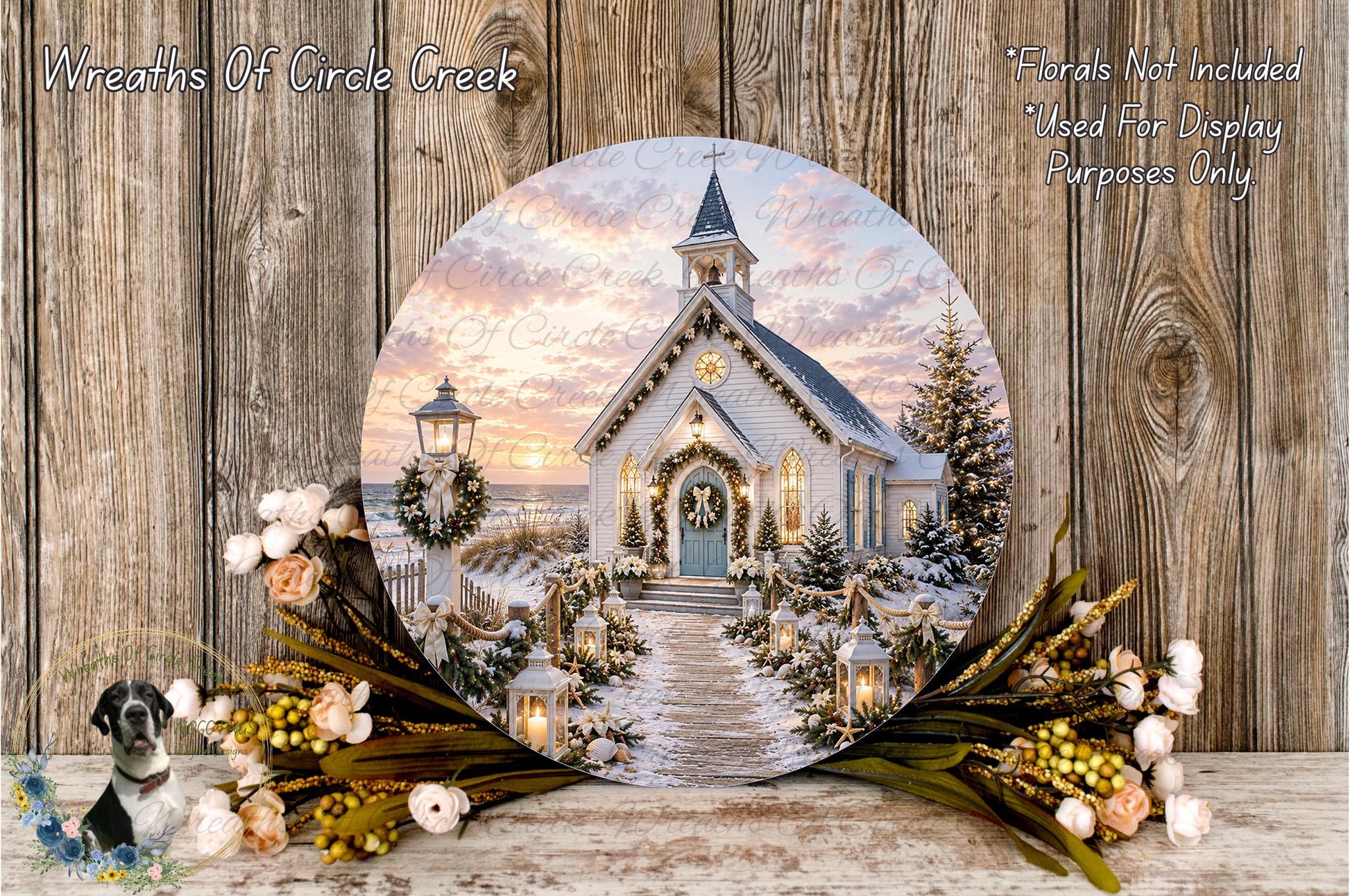 A round wooden plaque displaying a winter scene of a church with a wreath and flowers, set against a wooden background.