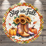A round decorative plate with a plaid border, featuring a pair of boots, sunflowers, pumpkins, and leaves, along with the text "Step into Fall".