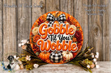 A decorative wreath with the text "Gobble 'til You Wobble" and various fall-themed elements such as pumpkins, flowers, and a bow. The wreath is displayed on a wooden surface, surrounded by additional fall-themed decorations.