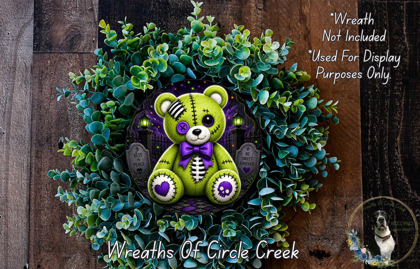 A wreath made of green and purple fabric, featuring a teddy bear with a purple bow and a skull design, surrounded by green foliage.