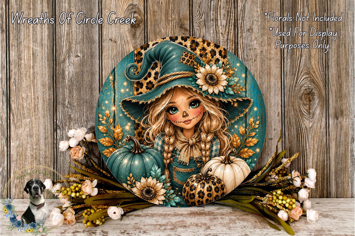 A round, decorative wreath featuring a cartoon girl with a pointed hat and floral elements, including pumpkins and flowers, set against a wooden background.