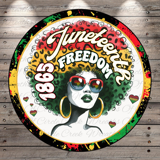 A colorful circular logo featuring a stylized illustration of a woman with a large afro hairstyle, sunglasses, and the text "JUNEEENTH" and "FREEDOM" prominently displayed.