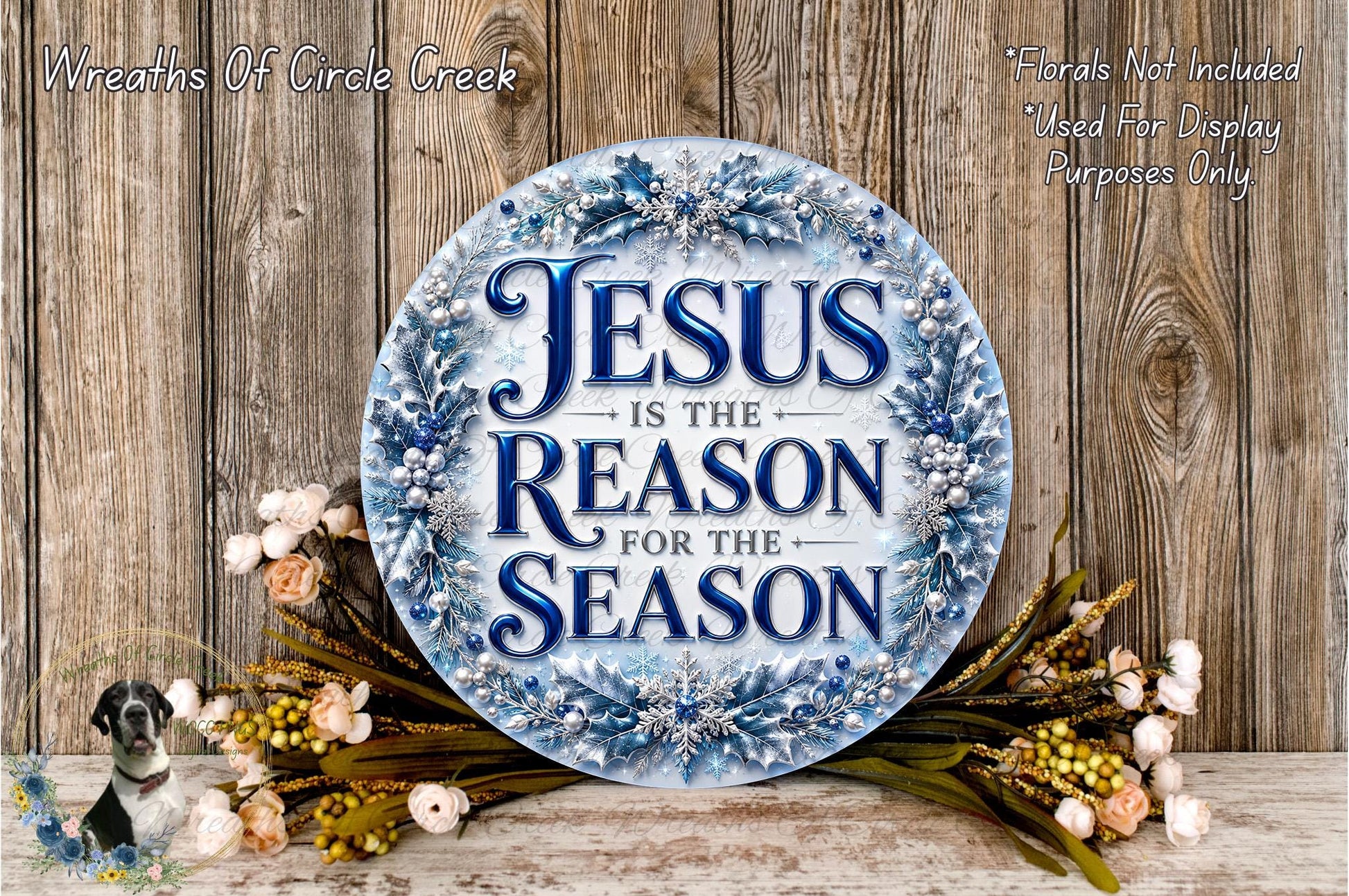 a circular sign with the text "JESUS IS THE REASON FOR THE SEASON" surrounded by a wreath of flowers and greenery.