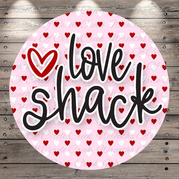 A circular design with the text "I Love Shack" written in a stylized font, surrounded by a pattern of red hearts on a pink background.