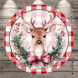 A deer with antlers is depicted in a festive wreath, surrounded by berries and pine branches, all set against a red and white checkered background.