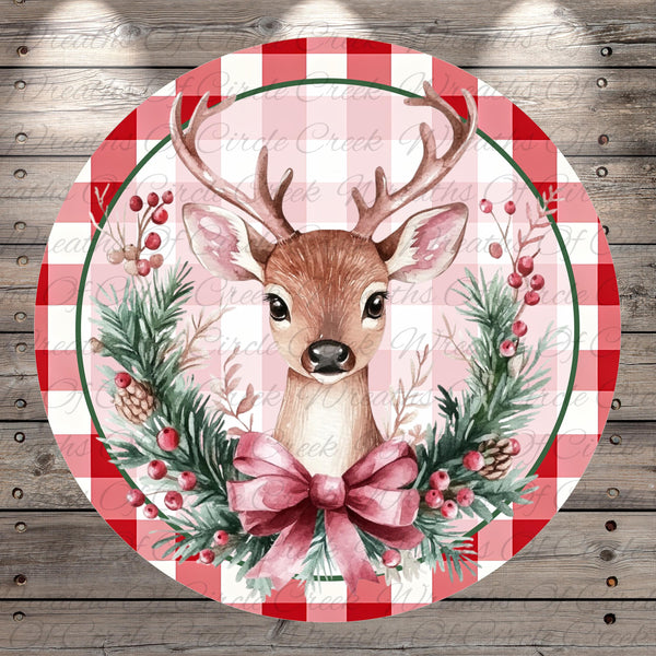 A deer with antlers is depicted in a festive wreath, surrounded by berries and pine branches, all set against a red and white checkered background.