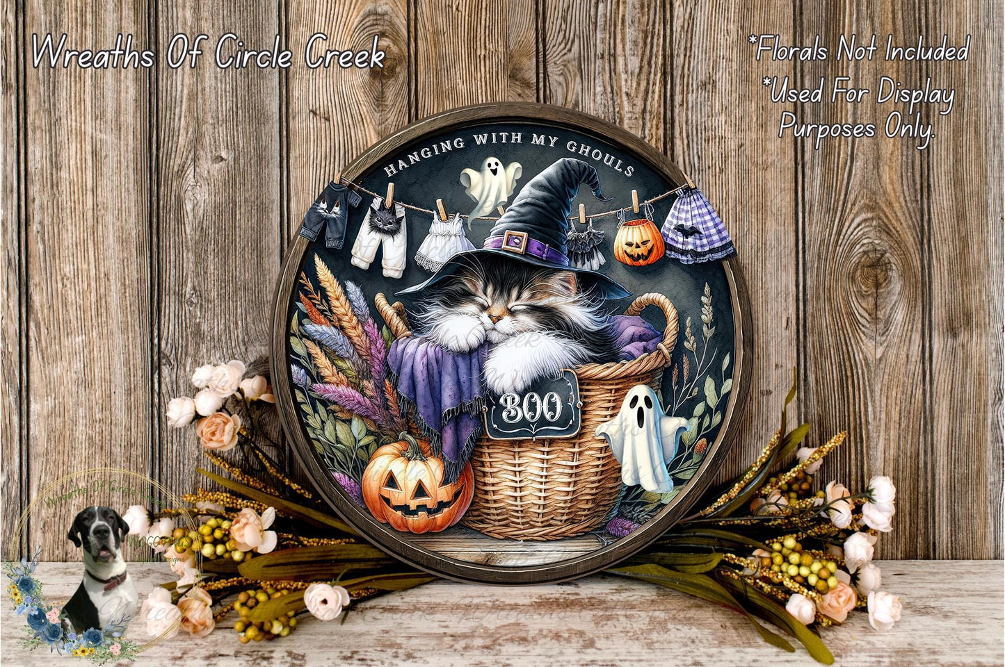 A decorative Halloween wreath featuring a cat wearing a witch's hat, surrounded by pumpkins, flowers, and clothespins.
