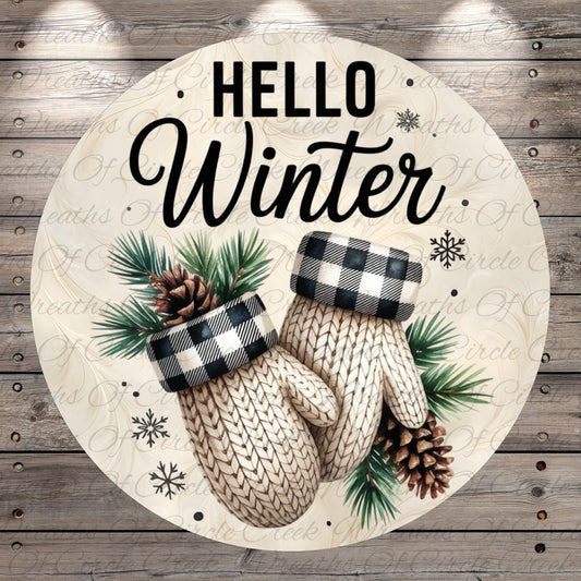 A circular design with a winter theme, featuring a pair of white mittens with black and white plaid accents, pine cones, and pine needles. The text "Hello Winter" is displayed prominently in the center of the image.