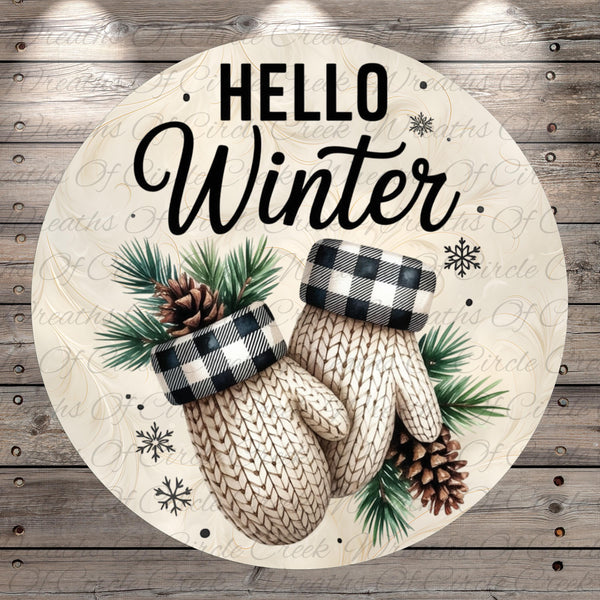 A circular design with a winter theme, featuring a pair of white mittens with black and white plaid accents, pine cones, and pine needles. The text "Hello Winter" is displayed prominently in the center of the image.