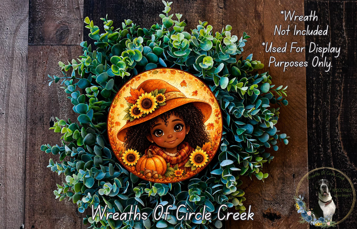 A wreath featuring a smiling young girl wearing a hat and holding a pumpkin, surrounded by green foliage and sunflowers.