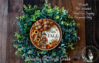 a wreath with a picture of a scarecrow and sunflowers