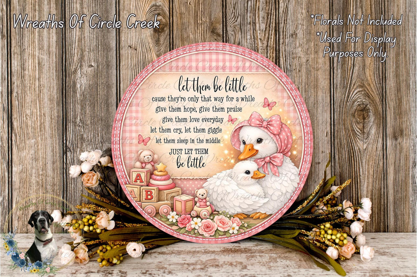 A decorative plate with a pink and white color scheme, featuring a mother duck and her ducklings surrounded by flowers and baby toys. The plate has a message that reads "Let them be little cause they're only that way for a while give them hope, give them praise, give them love everyday let them cry, let them giggle let them sleep in the middle just let them be little".