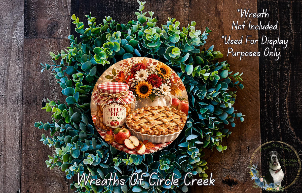 A wreath made of green leaves and flowers, with a pie and a jar of jam placed on top.