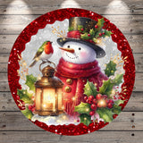 A snowman wearing a red scarf and hat, with a bird perched on its shoulder, stands next to a lantern and holly leaves, all set against a snowy background.
