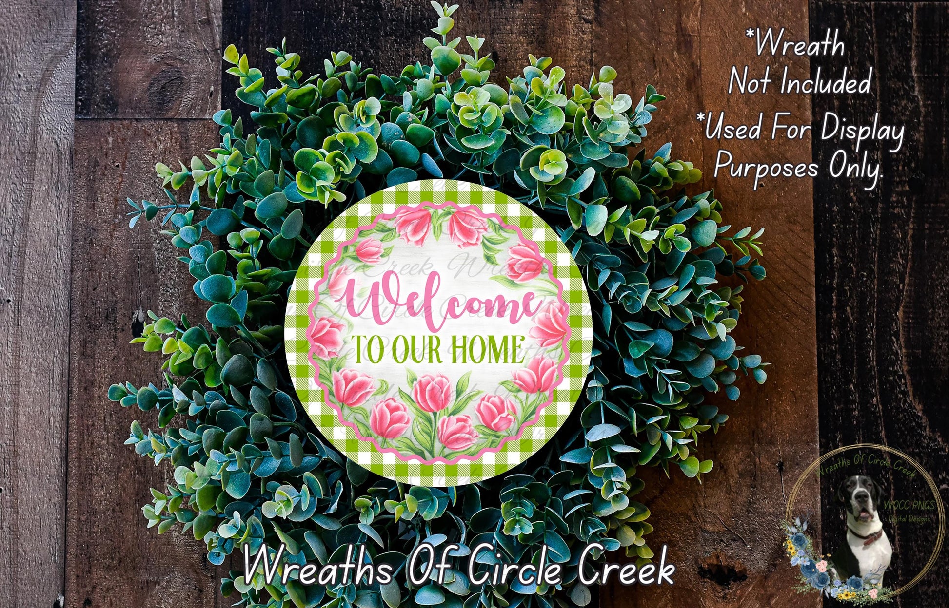 a wreath made of various green and pink flowers, with a circular sign in the center that reads "Welcome to our home".