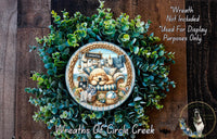 A wreath made of green foliage, featuring a central image of a dog and a sign that reads "Sconce". The wreath is displayed on a wooden surface, and there is text in the top right corner that reads "Wreath Not Included * Used For Display Purposes Only".