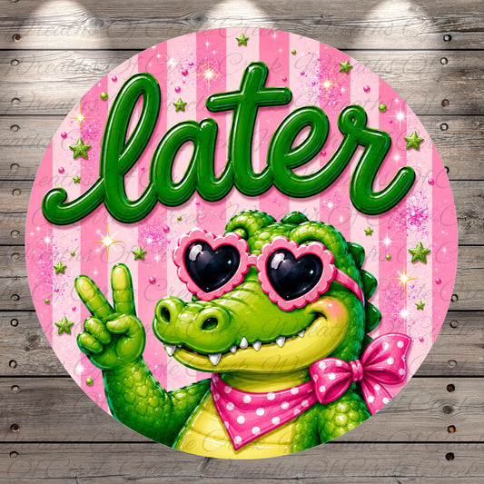 A green alligator wearing sunglasses and a pink bow tie is making a peace sign with its right hand against a pink background with stars and the word "later" written in green.